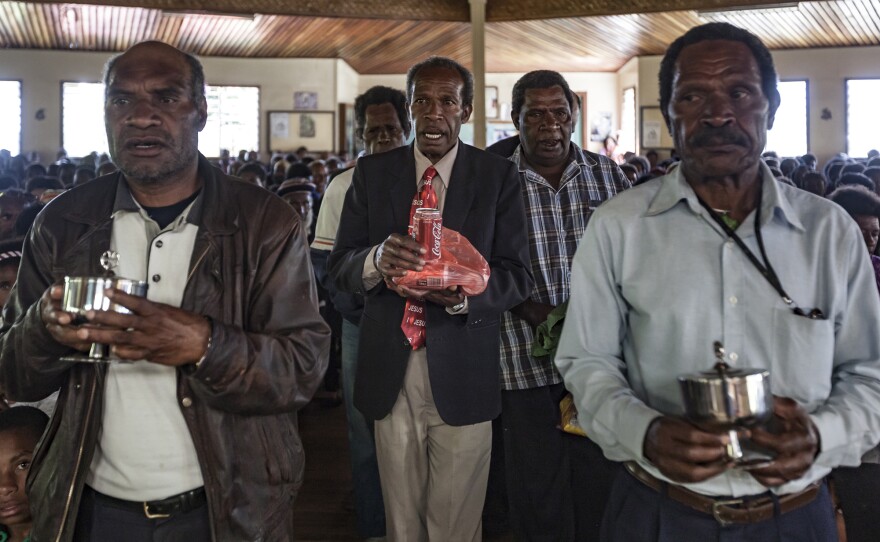 Coca-Cola is part of a spiritual offering, replacing sugar cane, at the Sunday service at Sagurap Catholic Church in the village of Wabag, in Papua New Guinea's Enga Province.