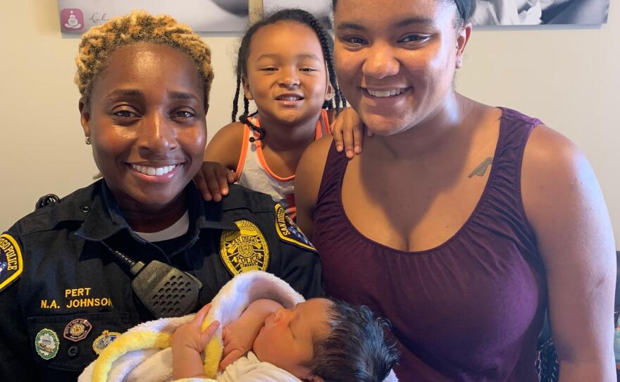 Nasira Johnson (left) holds her newborn son, Asir, with wife Sharavyn and Sharavyn's daughter Makayla, July 2019.