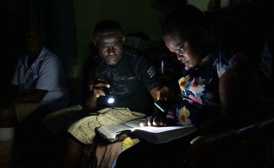Ferrier Petit Homme (left) and Sherrine Petit Homme LaFrance pray every evening with other Dorian evacuees as well as members of the Laguerre family, who welcomed them into their home. This night was particularly painful: Sherrine's 14-year-old son ran away in the morning. He returned two days later.