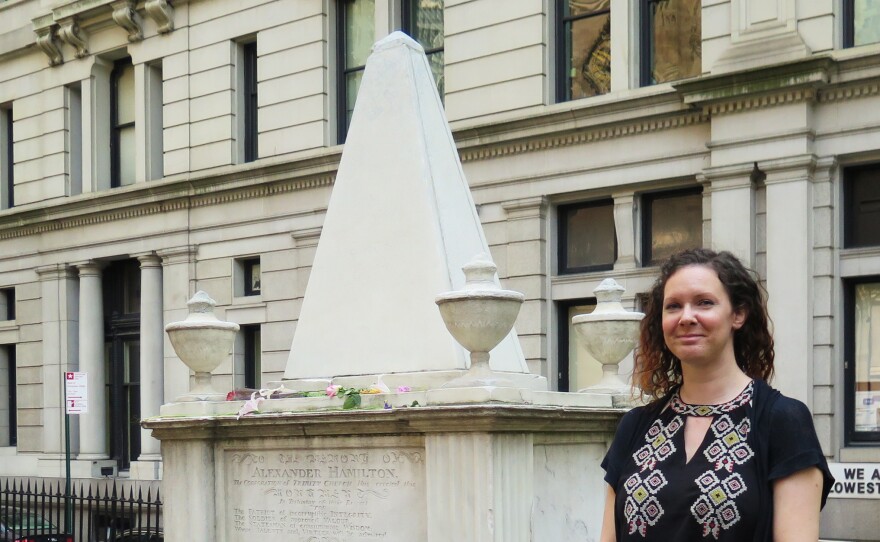 Trinity Church archivist Anne Petrimoulx stands in front of Alexander Hamilton's grave in New York City. The site has seen a surge in visitors following the popular Broadway musical, Hamilton.