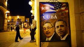 A poster features portraits of Cuba's President Raul Castro, left, and U.S. President Barack Obama and reads in Spanish "Welcome to Cuba" outside a restaurant in Havana, Cuba, March 17, 2016.