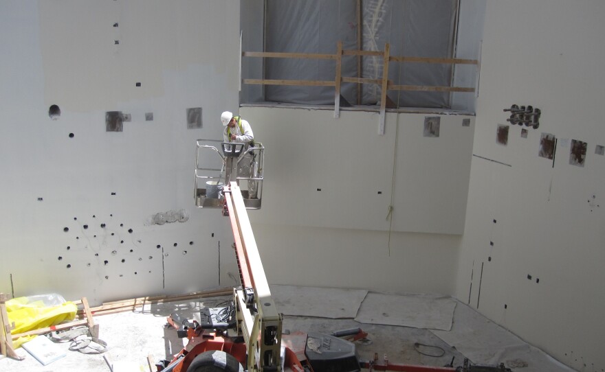 A construction worker paints walls at the Maryland Proton Treatment Center in Baltimore. Each of the center's five rooms will contain a massive piece of equipment that will rotate around a cancer patient to deliver a special kind of radiation.