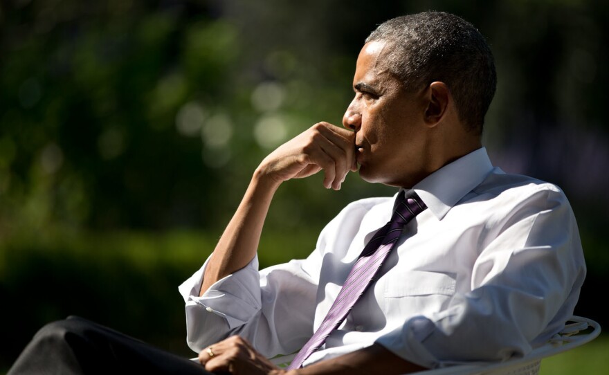 The president listens during a meeting with staff in the Rose Garden on Oct. 8, 2014.