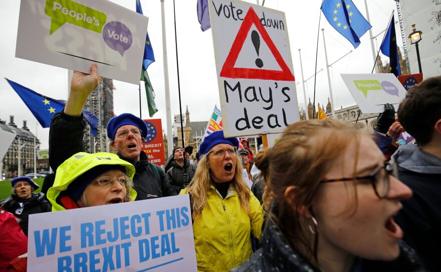 Anti-Brexit activists hold placards and wave flags as they demonstrate outside the Houses of Parliament in London on Tuesday, ahead of a crucial vote on Prime Minister Theresa May's Brexit deal.