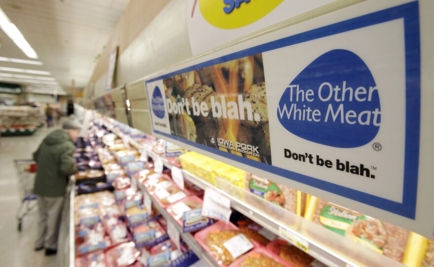 In this 2011 photo, a banner in an Iowa grocery store advertises "pork, the other white meat" — the former, long-running slogan of the National Pork Board. Funded by money collected by the federal government, the board is one of a dozen promotional funds for different parts of American agriculture.