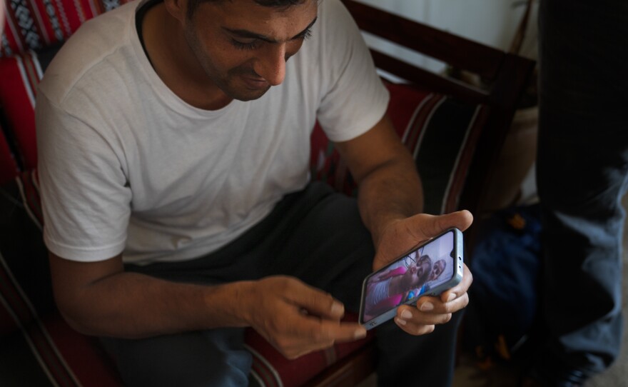 Alfarany looks at pictures of his two young daughters making faces to the camera.