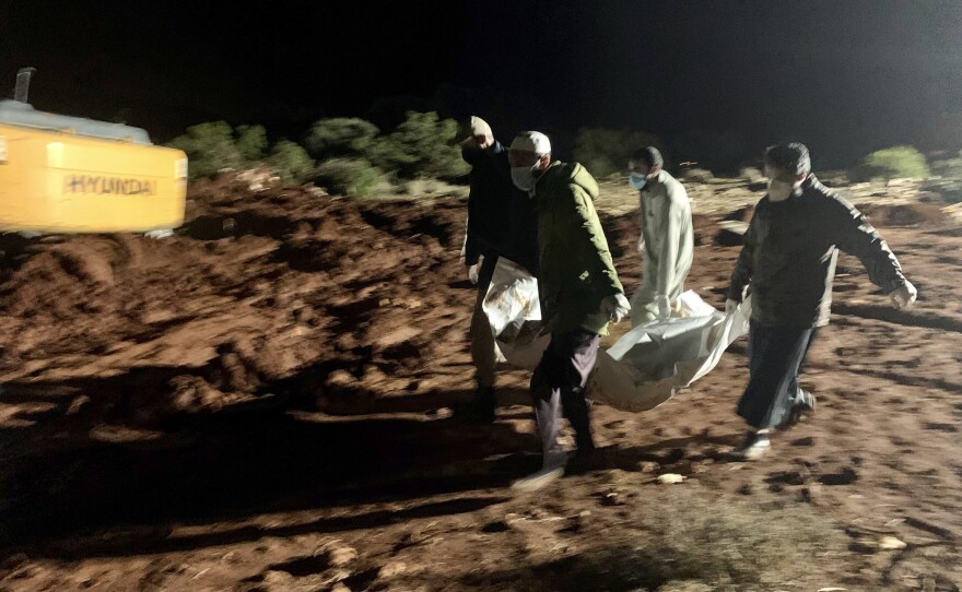 Workers bury the bodies of victims of recent flooding caused by Mediterranean storm Daniel near the city of Derna, Libya, late Tuesday, Sept. 12.