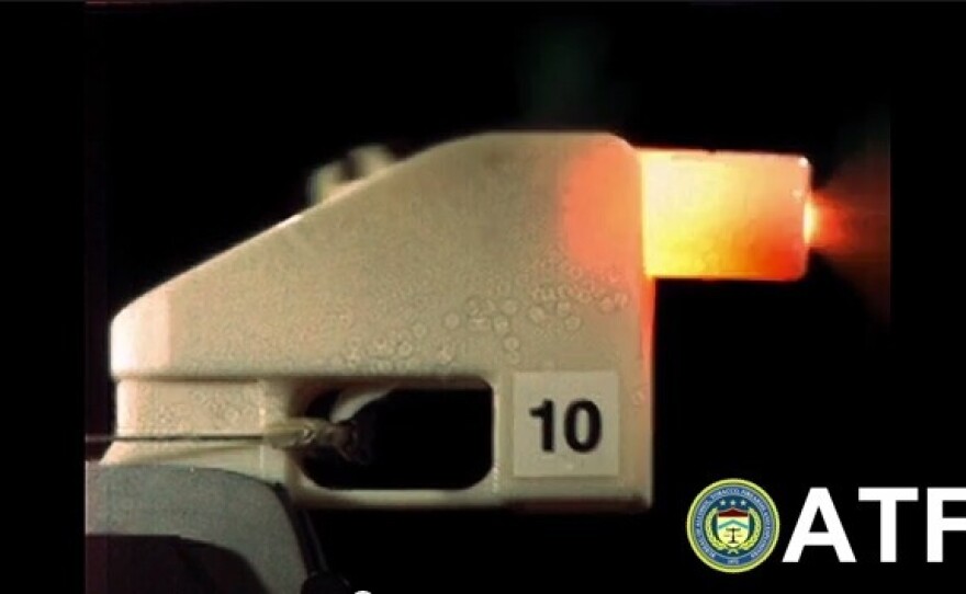 An all-plastic gun fires a bullet in this screenshot from a video made by the Bureau of Alcohol, Tobacco, Firearms and Explosives.