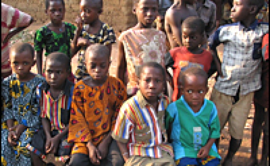 The children seated on the bench are cared for by their 89-year-old grandfather.