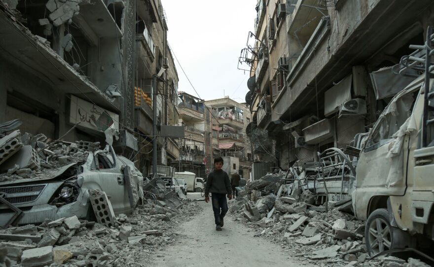 A Syrian child threads a path last week through the rubble of blasted buildings in the rebel-held town of Douma, in the enclave of eastern Ghouta outside Damascus.