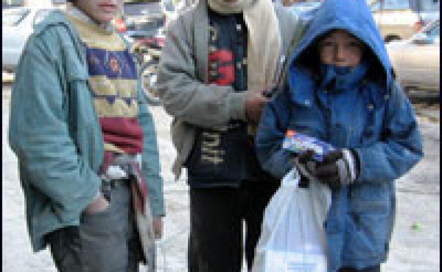 Ruzadin, 11, (left) holding his can of burning incense, stands with fellow street children in the trendy Shahre-Naw district of Kabul.