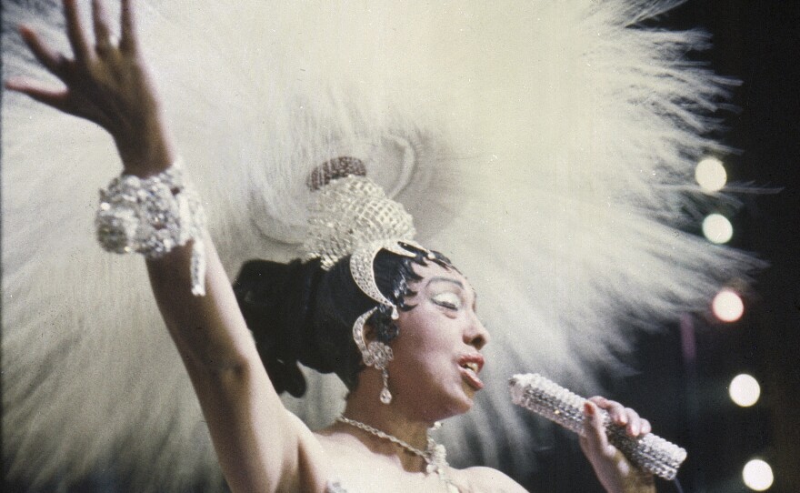 Josephine Baker holds a rhinestone-studded microphone as she performs during her show "Paris, mes Amours" at the Olympia Music Hall in Paris, France, on May 27, 1957.