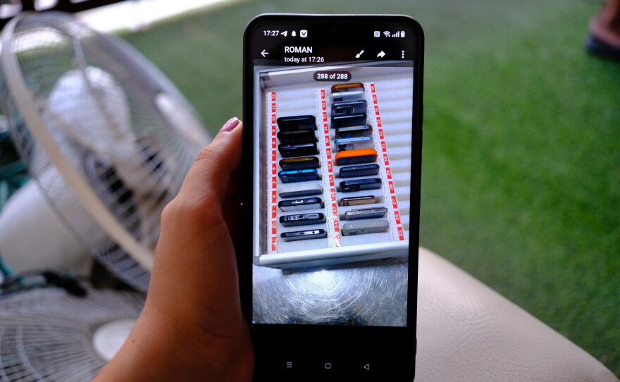 A man who worked in scam compound in Cambodia shows the only evidence he managed to document on his phone, a photo of dozens of phones that he was given to reach out and recruit potential scam victims.