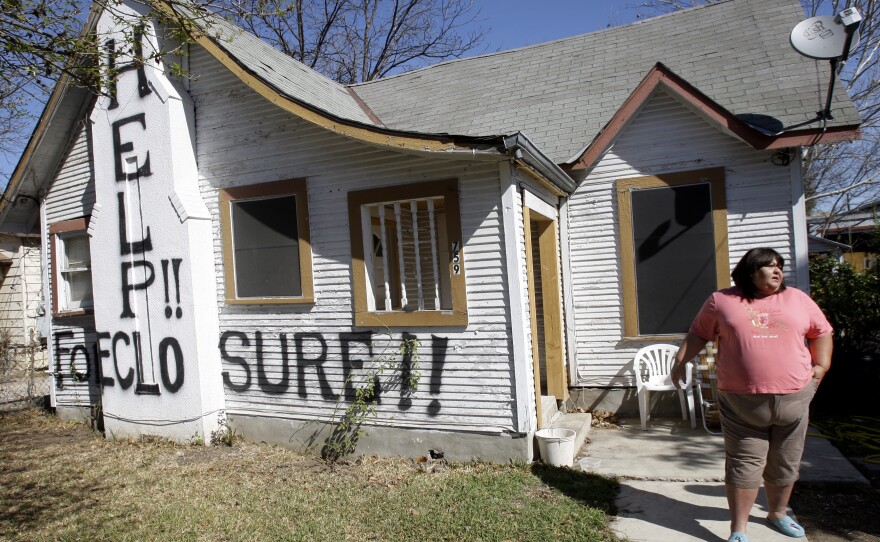 Mary Ann Herrera stands outside her home in San Antonio, on Feb. 23, 2009. Under the threat of foreclosure, Herrara's brother painted the words "Help!!" and "Foreclosure!!" on her home in the hopes of receiving assistance.