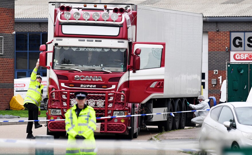 Police and forensic officers investigate a truck and refrigerated trailer where 39 bodies were discovered in Thurrock, England.