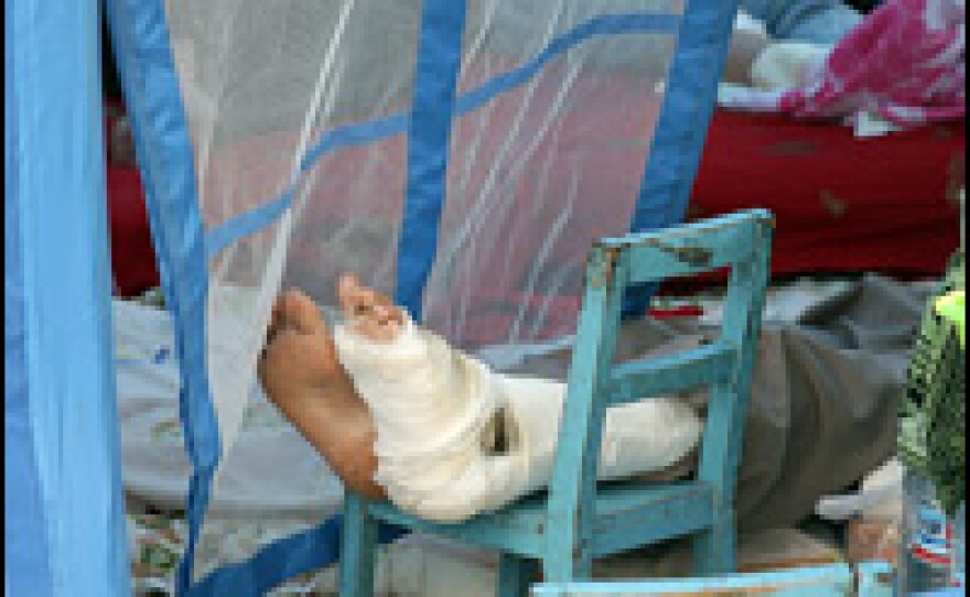 A patient's bandaged foot is elevated in a makeshift hospital.