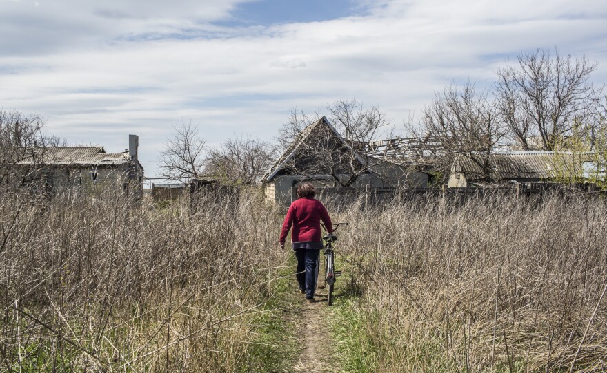 Vera Anoshina walks her bicycle down a path in Spartak in April.