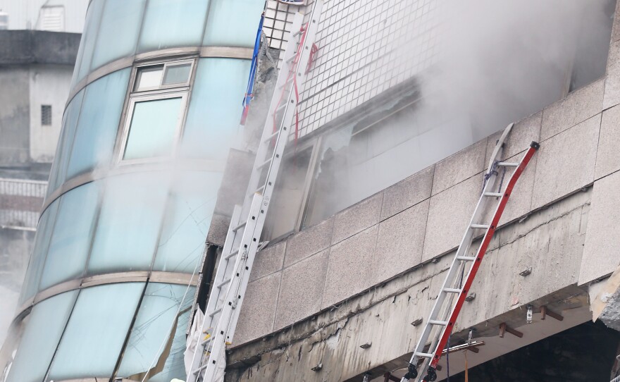 Rescue workers search for survivors in a damaged building on Wednesday, bracing themselves for the aftershocks that continued to rattle Taiwan after the deadly earthquake.