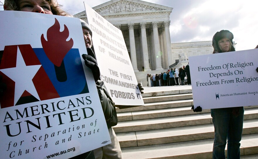 Activists hold posters during a rally in front of the U.S. Supreme Court to support separation of church and state in March 2005 in Washington, D.C. The Supreme Court heard two cases on whether Ten Commandments monuments should be displayed on government properties.