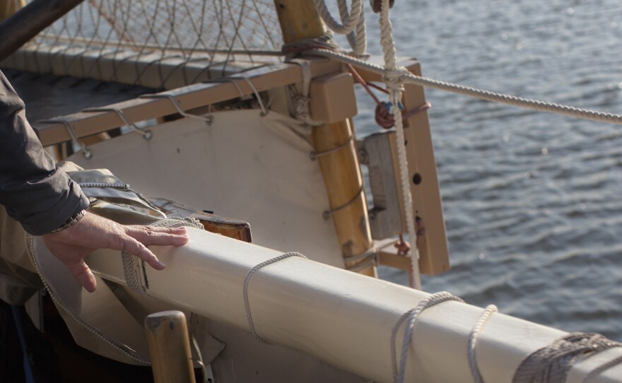 Na'alehu Anthony's hand rests over a small black mark on the rail of the boat. Marks like this create a grid on the entire boat to help orient the navigator in the direction which they are heading.