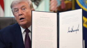 President Trump holds his signed executive order that calls for restricting voting by mail in the White House's Oval Office in March.