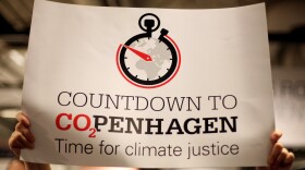 An environmentalist holds a banner reading 'Countdown to CO2PENHAGEN Time for climate justice' during the fourth day of the United Nations Climate Change Conference 2009 on December 10, 2009 in Copenhagen, Denmark.