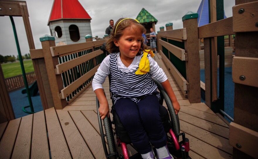 Brooklyn Fisher rolls down the ramp on the playground named for her in Pocatello, Idaho. The playground was built using accessible features so children of all abilities could play alongside each other.