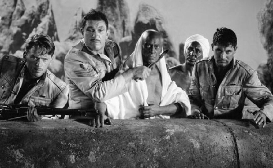 Douglas Fairbanks, Jr, Victor McLaglen, and Cary Grant star as British soldiers with Eduardo Ciannelli (center) and Sam Jaffe (in back) starring as Indian characters in the 1939 film adaptation of Rudyard Kipling's "Gunga Din."