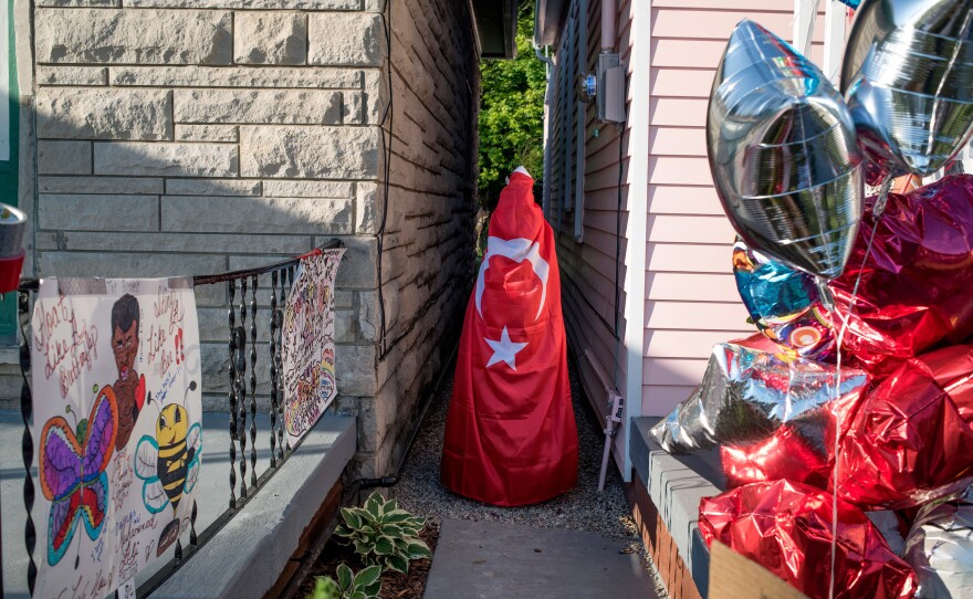 People place flowers and other gifts of remembrance around Muhammad Ali's childhood home on Grand Avenue in Louisville.