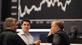 Stock traders converse at a stock exchange in Frankfurt. As a result of the financial crisis, analysts say the U.S. may be going through an economic transformation to become more like Europe.