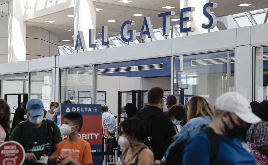 Travelers wearing protective face masks wait in line at a Transportation Security Administration (TSA) screening at LaGuardia Airport (LGA) in New York last month. Citing a surge in unruly passengers, U.S. aviation regulators are calling on the nation's airports to encourage the police to arrest offenders, and to prevent people from sneaking alcohol on board.