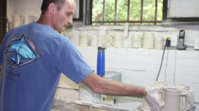 Bob Davis hand-dips mugs before they go into the kiln at American Mug and Stein in East Liverpool, Ohio. Most overseas companies have machines that can do this much faster.