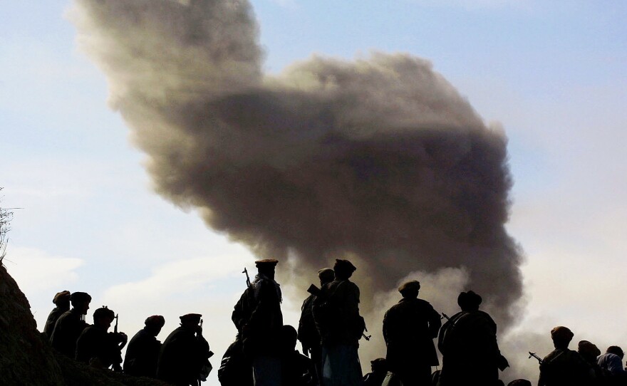 Northern Alliance soldiers, aligned with the U.S., watch as American warplanes drop bombs on the Taliban on Nov. 19, 2001, around the city of Kunduz, Afghanistan. The U.S.-led coalition quickly drove the Taliban from power, but 15 years later, the Americans are still helping the Afghan army battle the Islamist radicals.