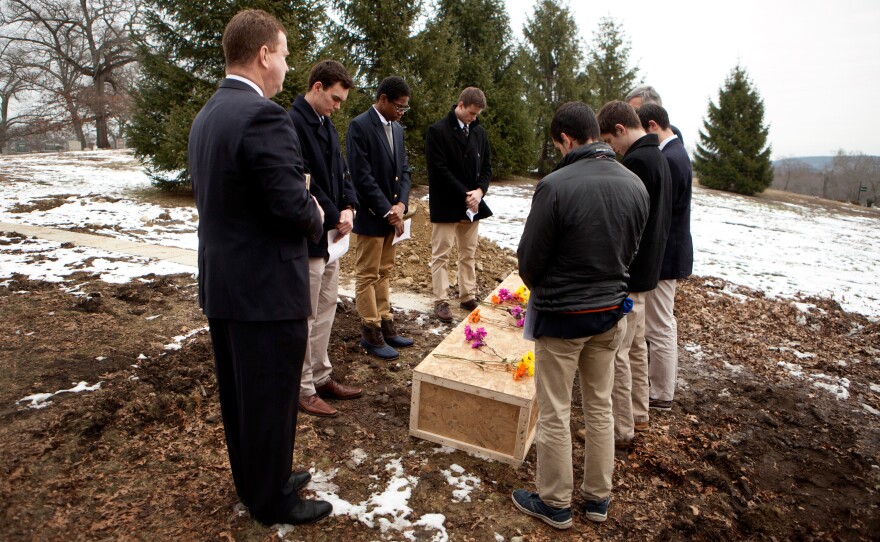 From left to right, funeral director Rob Lawler; Roxbury Latin students Emmett Dalton, Noah Piou and Chris Rota; Roxbury Latin assistant headmaster Mike Pojman, and Roxbury Latin students Brendan McInerney, Liam McDonough and Esteban Enrique conduct a graveside prayer service for Nicholas Miller on Friday at the Fairview Cemetery.