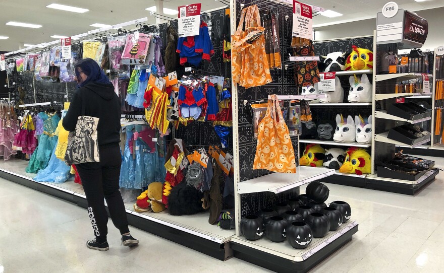 A customer looks through kids Halloween costumes at a Target department store on Tuesday, Oct. 2, 2018, in Aventura, Fla.