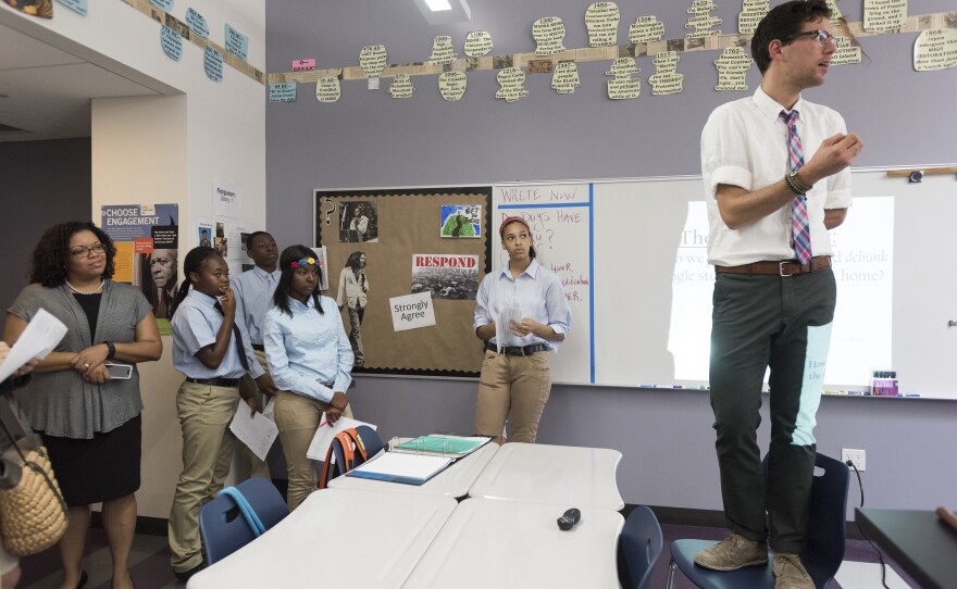 As Principal Melissa Jarvis-Cedeño looks on, Taylor Delhagen directs students to various stations around his classroom. His global history class can feel like a theatrical production.
