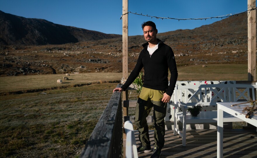 Kunuk Nielsen stands on the deck of his family's home. He's spent his entire life on the sheep farm.
