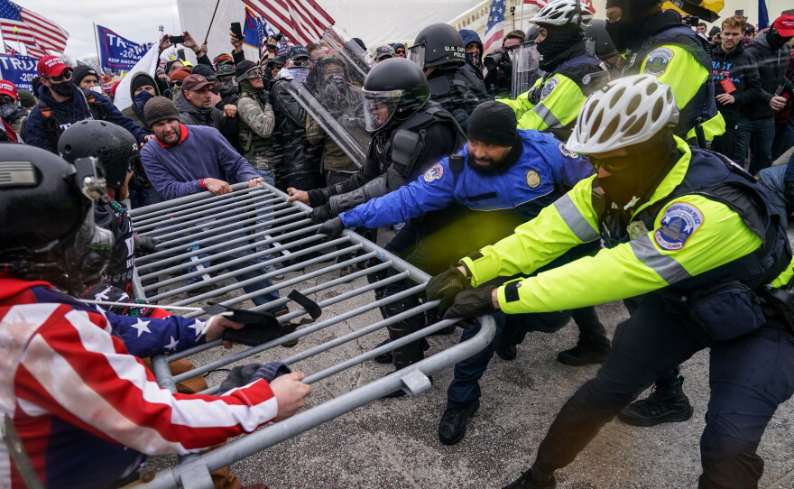 FILE - Trump supporters try to break through a police barrier, Jan. 6, 2021, at the Capitol in Washington.