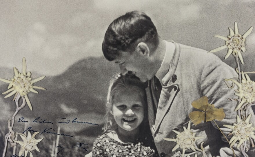 In this 1933 photo released by Alexander Historical Auctions, Adolf Hitler embraces Rosa Bernile Nienau at his mountainside Bavarian retreat in Germany. The photograph is inscribed by Hitler himself in dark blue ink.