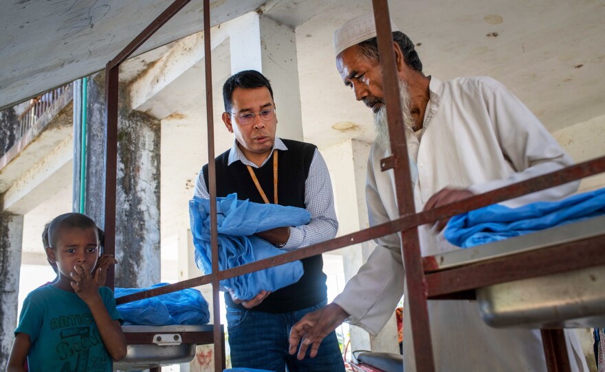 Dr. Ching Swe Phru helps disperse bed nets treated with insecticide. <strong></strong>Phru is grateful for the strides made against malaria but adds, "I'm afraid that malaria has a certain history of coming back."