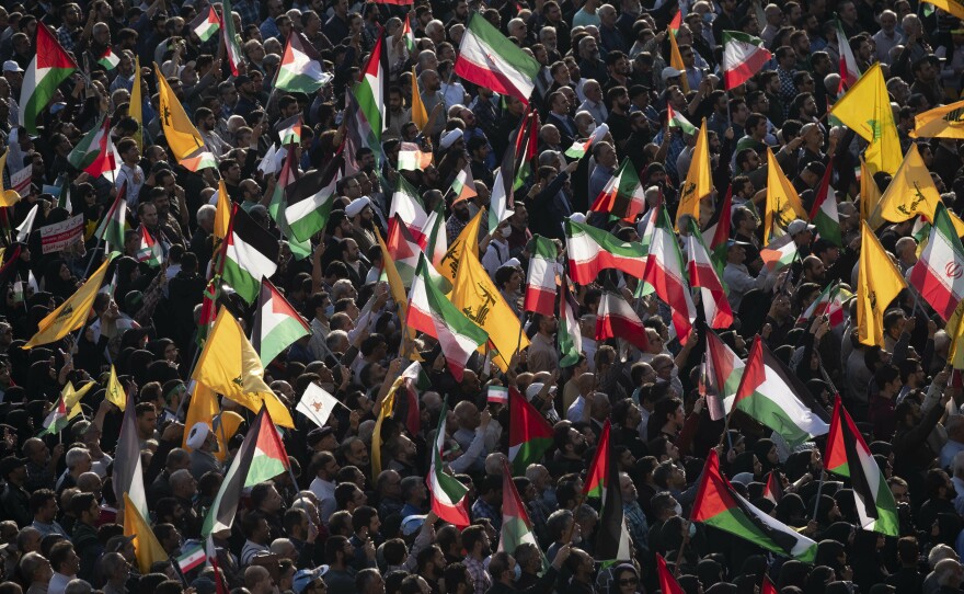 People carry Palestinian flags, Iranian flags and Hezbollah flags at Tehran's Revolution Square during an anti-Israel rally on Oct. 18.