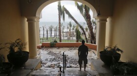 A tourists looks to the ocean from inside a debris-filled area at the Hilton hotel after the resort sustained severe damage from Hurricane Odile in Los Cabos, Mexico, Sept. 15, 2014. 