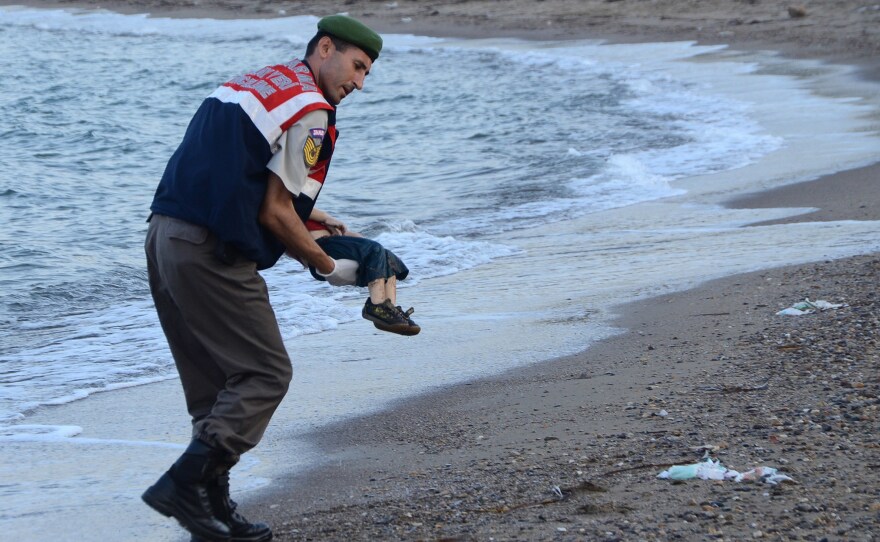 A Turkish paramilitary police officer carries the body of 2-year-old Syrian refugee Alan Kurdi, found washed ashore near the Turkish resort of Bodrum in September 2015.