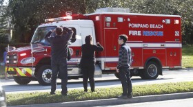 Anxious family members watch a rescue vehicle pass by in Parkland, Fla, Wednesday, Feb. 14, 2018. 