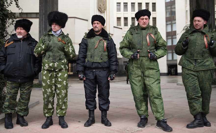 Cossacks stand guard at the entrance to the Crimean Parliament building on Friday in Simferopol, Ukraine. Russian Cossacks, some heavily armed, have taken up guard duties at road checkpoints, border crossings and other key facilities that were previously guarded by local, pro-Russian militants across Crimea in recent days.