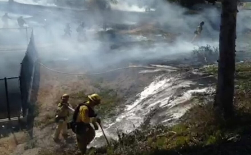 A Cal Fire crew works to put out a brush fire that erupted in Spring Valley on May 1, 2014.