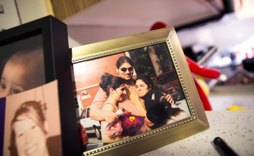 A photograph of Carlos Romero with his sisters in high school sits on the counter in Romero's apartment in Seattle.