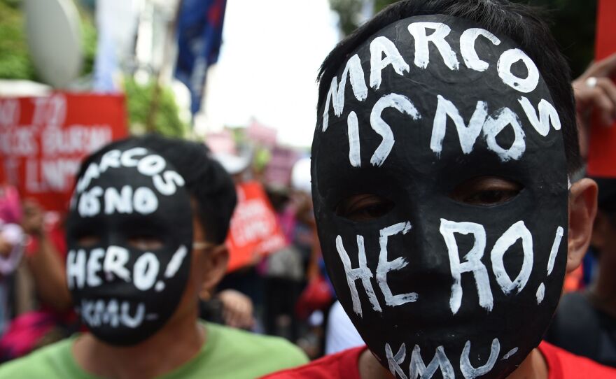 Activists wear masks with anti-Marcos slogans during a rally in front of the Supreme court in Manila in 2016 as they await the high court's decision on whether to allow the burial of the late Philippine dictator Ferdinand Marcos at the "Cemetery of Heroes".