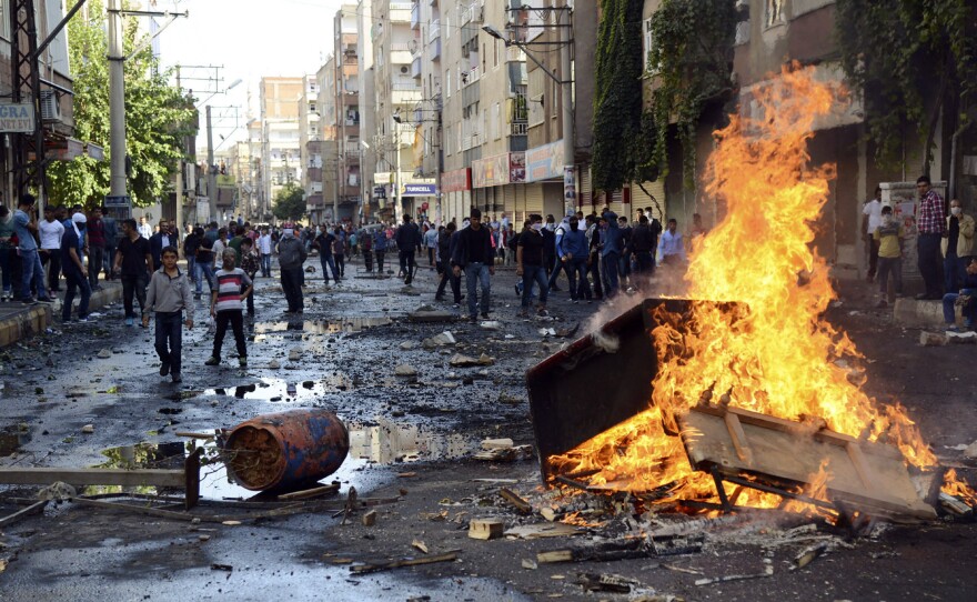 Kurdish protesters set fire to a barricade set up to block the street as they clash with riot police in Diyarbakir, Turkey, on Wednesday.