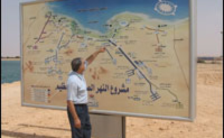 A government worker shows the scale of the Great Man-Made River Project.